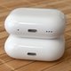 The new Apple AirPods Pro 2nd Generation charging case sitting on top of the original AirPods Pro charging case.